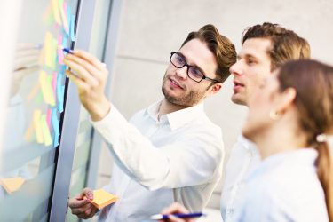 gruppe-von-geschaftsleuten-die-ideen-im-modernen-buro-teilen gruppe-von-geschaftsleuten-die-ideen-im-modernen-buro-teilen